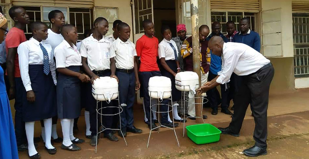 dr.-david-musoke-demonstrating-proper-hand-washing-to-students-at-bussi-secondary-schoolwakiso district
