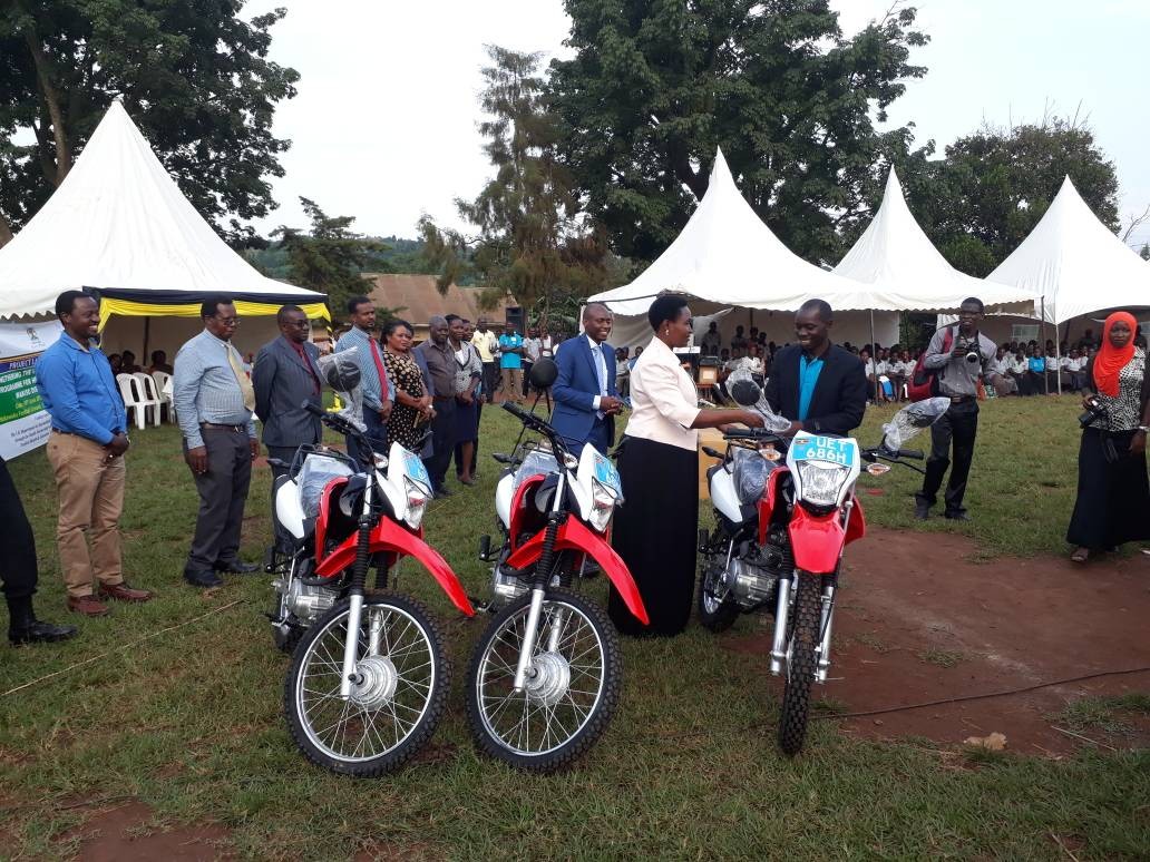 Figure 3 Paul Ahura (first left) looking on happily as one of the VHT Coordinators receives a key of one of the motorbikes from Hon Seninde.