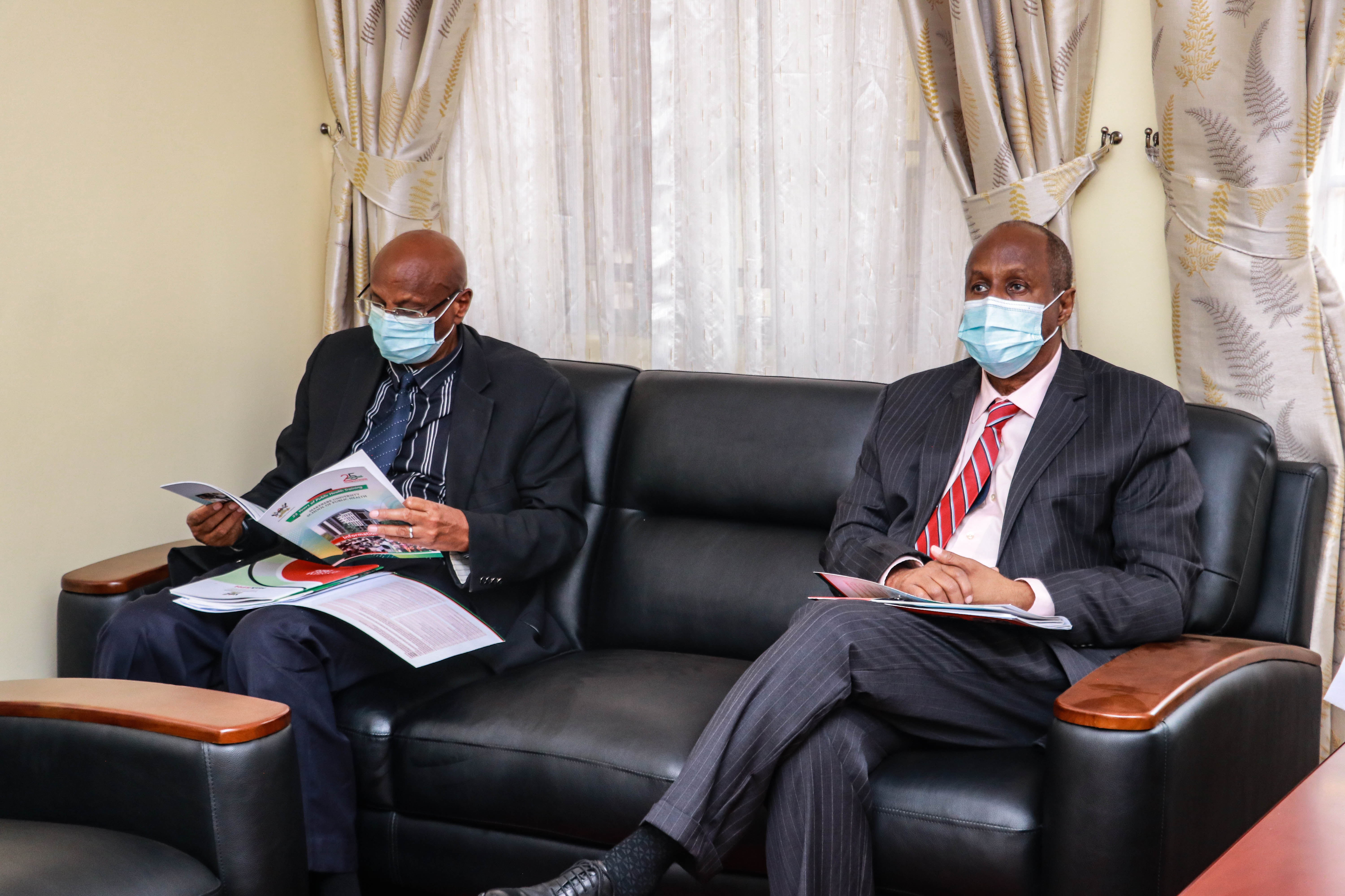 Prof. Hassan Omar Mahadalle, the Rector of Somalia National University (right) and Dean Faculty of Health Science & Tropical Medicine SNU. Dr.Mohamed Gedi Qayad reading Makerere information pack