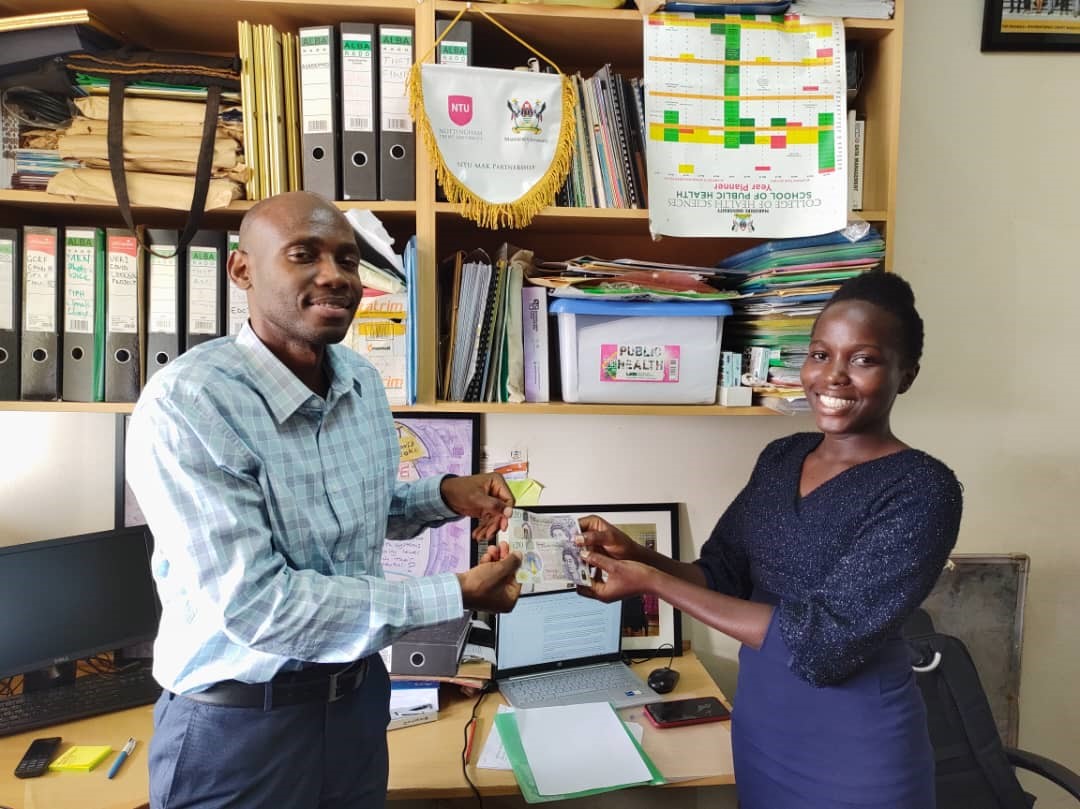 Dr David Musoke, the Ugandan Project Lead awarding Nabaigwa Doreen, a student from Makerere University who was highly recommended in the comic strip category.