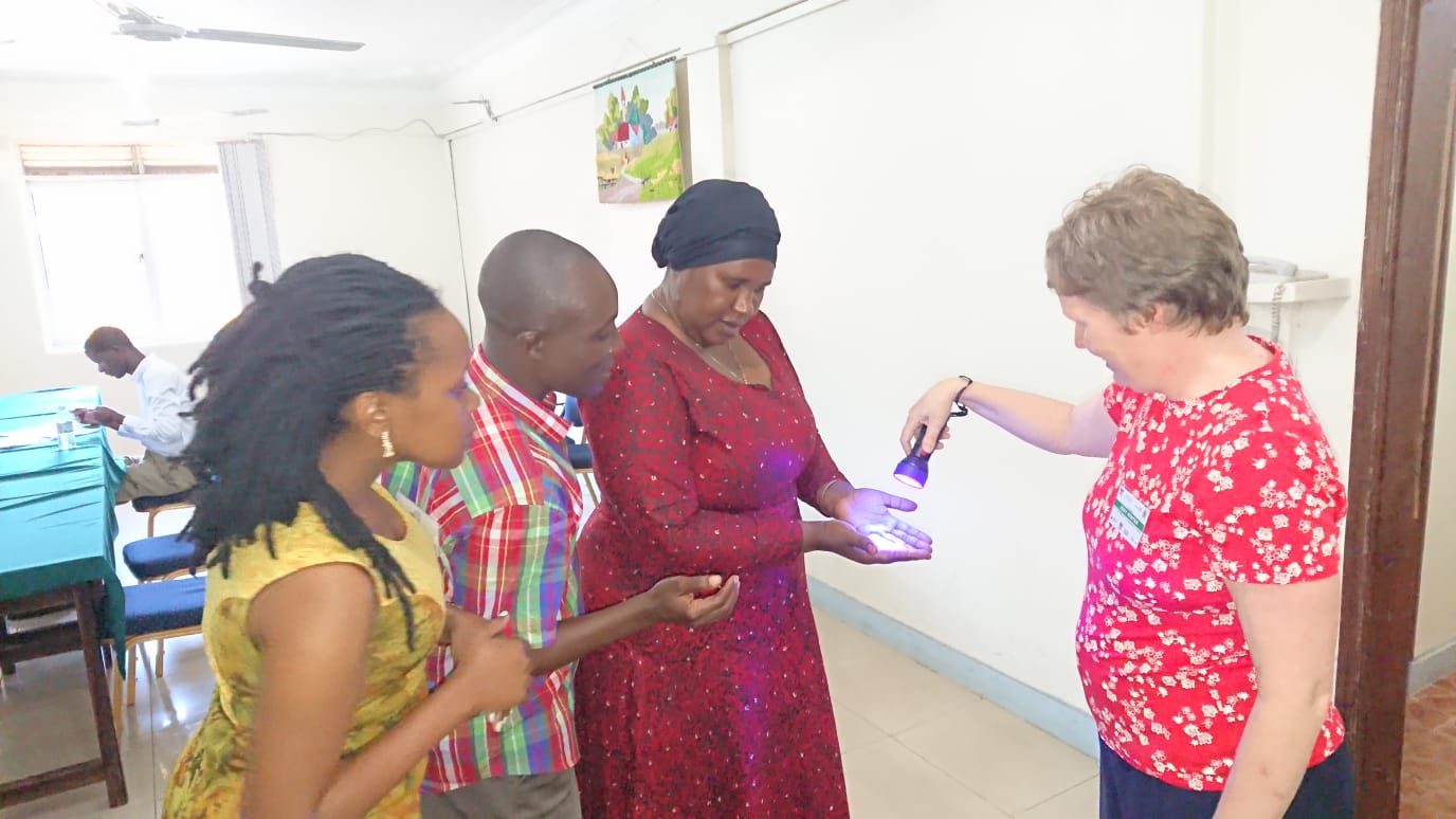 Dr. Jody Winter from Nottingham Trent University using the Glow Germ Gel Kit to demonstrate the proper handwashing procedure during the training of health practitioners in Entebbe.