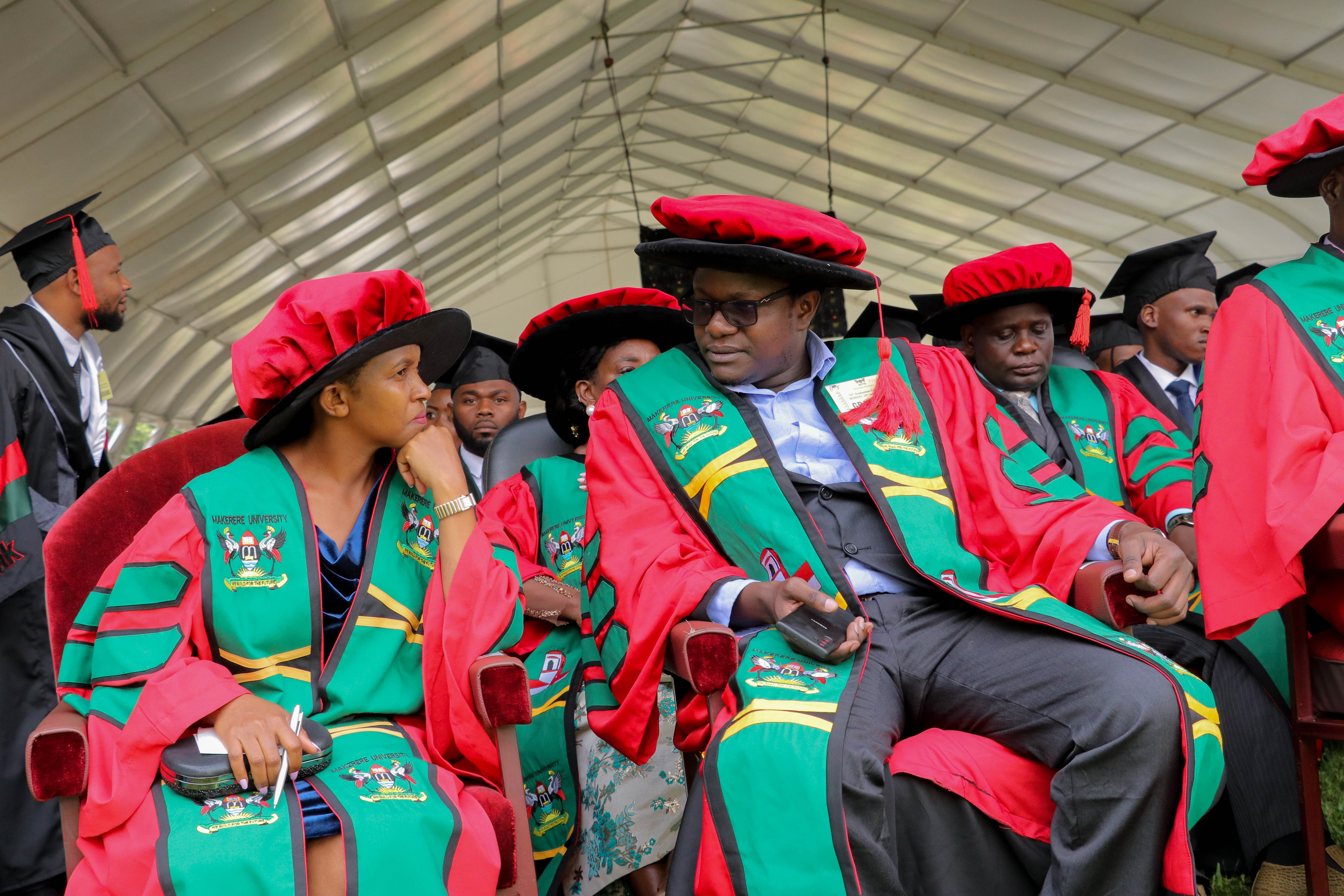 Dr. Muleme James interacts with a colleague during the Mak74thGrad ceremony at the Freedom Square.