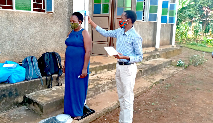 Filimin Niyongabo (right) taking weight and height measurements of VHTs on arrival. The measurements were used in calculation of Body Mass Index (BMI).