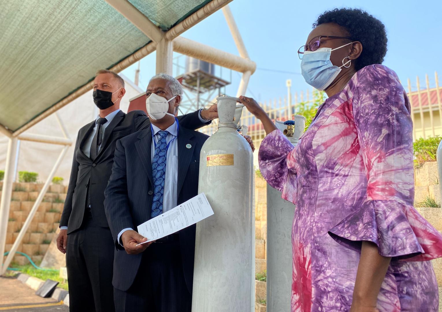WHO Representative to Uganda, Dr Yonas (blue tie) and the Danish Ambasador to Uganda H.E Nicolaj Petersen (black mask) hand the cylinders over to the Minister of Health Dr Jane Ruth Aceng ©WHOUganda