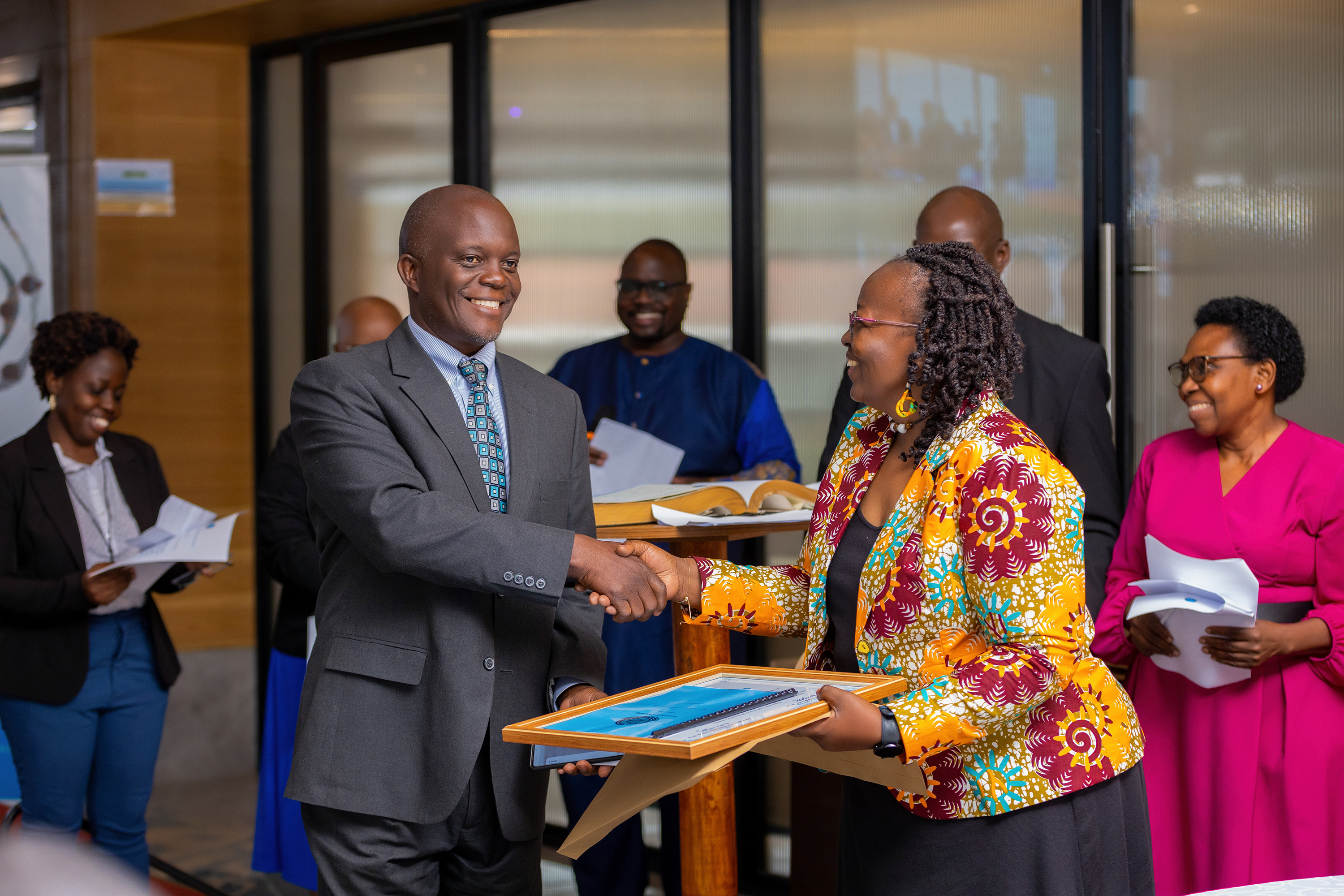 Dr. Fredrick Edward Makumbi receives a certificate of members from the UNAS president Prof. Grace Bantebya