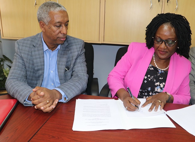  Dr. Rhoda Wanyenze, Dean School of Public Health signing the MoU. On Left; is the WHO, Country Representative to Uganda Dr. Yonas Tegegn Woldemariam.