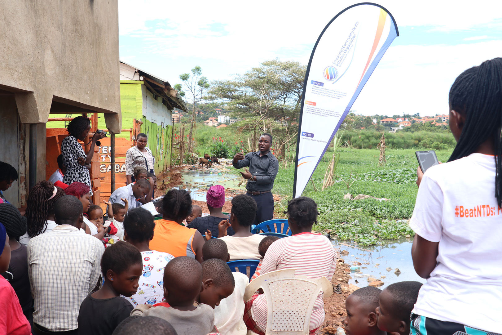 Arnold Tigaiza, member of ICHIO speaks to the community about NTDs and sanitation challenges in their community